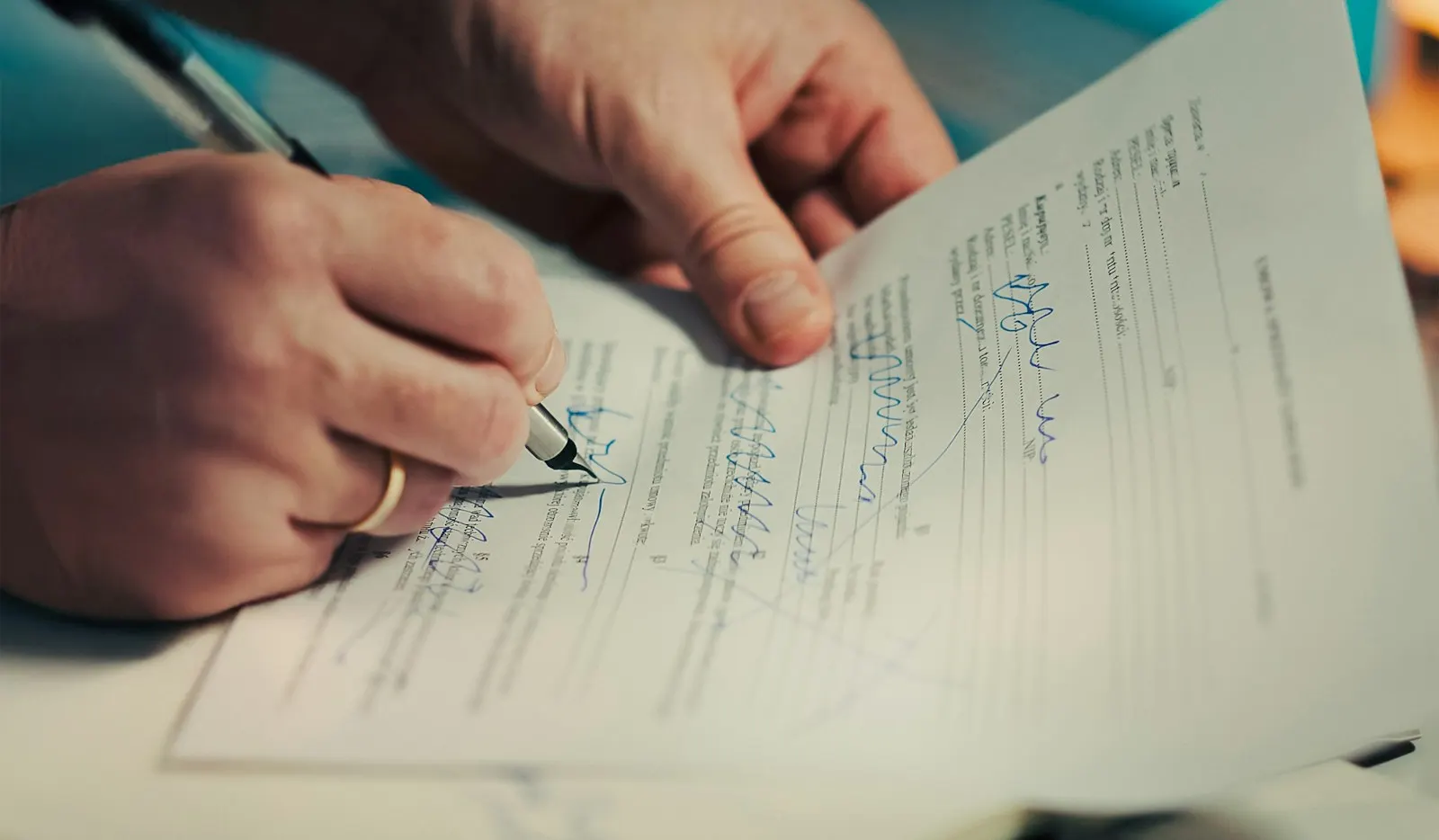A hand signing a property document with a pen